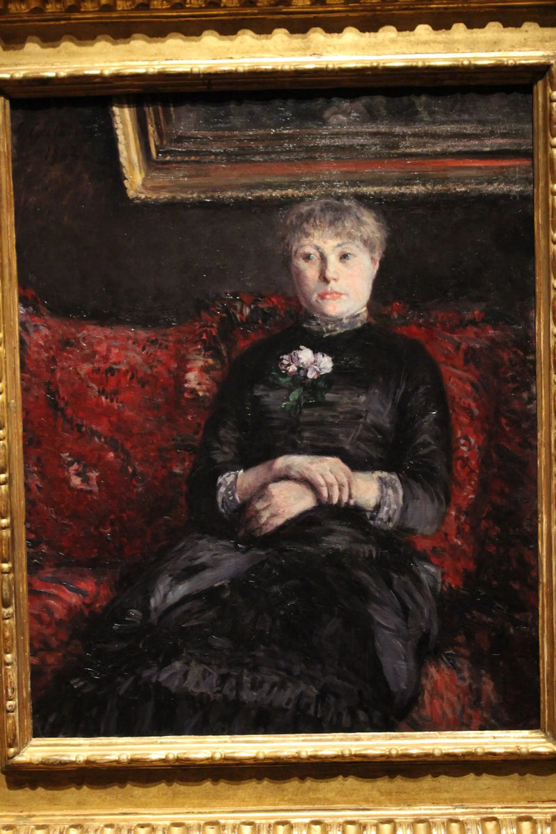 Kvinde siddende på en sofa med røde blomster - Gustave Caillebotte